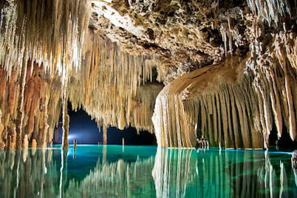 Underground river at Rio Secreto nature reserve with stalactites and crystal-clear water